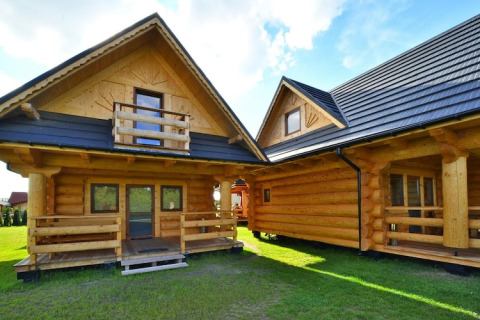 Twee blokhutten met houten veranda’s op het domein Highlander cottages ZUMAR Wicie in Denemarken.