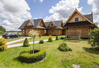 Cabanes en bois avec toits noirs, jardin et balançoire au Highlander cottages ZUMAR Wicie au Danemark.