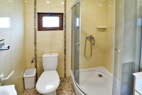 Bright bathroom at Domki letniskowe Rusinowo featuring shower cabin, toilet and window in Denmark.