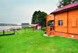 Holzhaus am See Domek letniskowy PATRYK Ostrowiec Slawienski mit Steg und Wiese in Dänemark.