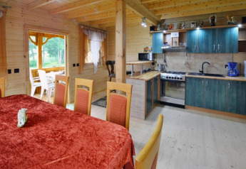 Cucina e sala da pranzo rustiche nel lodge Domek letniskowy PATRYK Ostrowiec Slawienski, interni in legno.