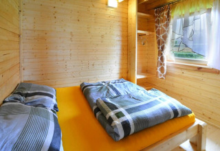 Helles Holzschlafzimmer im Domek letniskowy PATRYK Ostrowiec Slawienski mit Bett und Fenster.