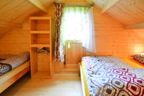 Gemütliches Schlafzimmer mit zwei Einzelbetten, Holzwänden und Fenster im Domek letniskowy PATRYK.