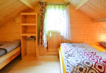 Dormitorio acogedor de madera abuhardillado con dos camas en Domek letniskowy PATRYK, Dinamarca.