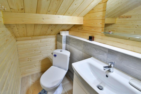 Modernes Bad mit Dachschräge, weißer Toilette und Waschbecken in Domek letniskowy PATRYK, Ostrowiec Slawienski.