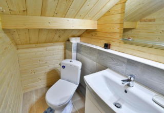 Modernes Bad mit Dachschräge, weißer Toilette und Waschbecken in Domek letniskowy PATRYK, Ostrowiec Slawienski.
