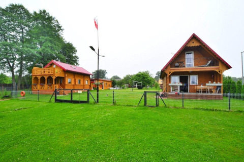 Foto von Domek letniskowy PATRYK Ostrowiec Slawienski, einer charmanten Lodge auf einem grünen Grundstück.