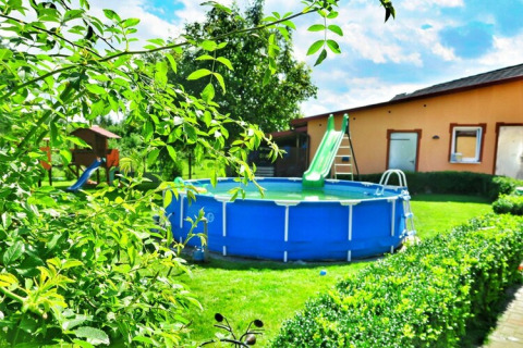 Garten im Domek letniskowy PATRYK Ostrowiec Slawienski mit Aufstellpool, Rutsche und Grünfläche