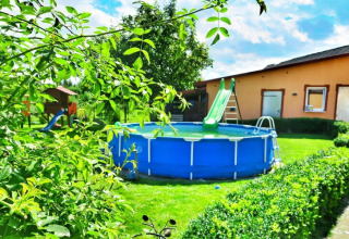 Garten im Domek letniskowy PATRYK Ostrowiec Slawienski mit Aufstellpool, Rutsche und Grünfläche