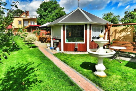 Gartenansicht der Lodge Domek letniskowy PATRYK Ostrowiec Slawienski in Dänemark mit Pavillon und Brunnen.