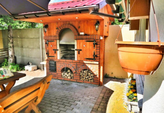 Gemütlicher Außenbereich mit Holzofen und Sitzbank bei Domek letniskowy PATRYK Ostrowiec Slawienski in Dänemark.