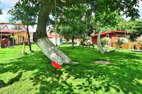 Grüner Garten mit Schaukeln und Bäumen bei Domek letniskowy PATRYK Ostrowiec Slawienski in Dänemark.