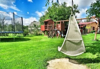 Spielplatz im Domek letniskowy PATRYK Ostrowiec Slawienski in Dänemark mit Schaukel, Trampolin und Spielhaus.