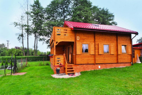 Blockhütte mit rotem Dach und Terrasse im Grünen bei Domek letniskowy PATRYK Ostrowiec Slawienski.