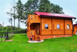 Blockhütte mit rotem Dach und Terrasse im Grünen bei Domek letniskowy PATRYK Ostrowiec Slawienski.