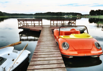 Muelle de madera con bote pedal con forma de coche en Domek letniskowy PATRYK Ostrowiec Slawienski, Dinamarca.