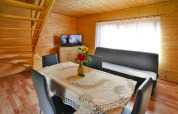 Sala en Domek 5-osobowy Jarosławiec, Dinamarca, con mesa de comedor, sofá, TV y detalles en madera.