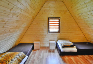 Houten kamer in Domek 5-osobowy Jarosławiec, Denemarken, met twee bedden en panterprint dekens.