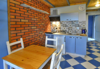 Cozy kitchenette at Domki wakacyjne Jezierzany in Denmark with brick walls and blue checkered flooring.