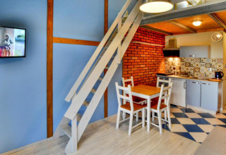 Moderne indretning i en lodge med hems, spiseområde, tekøkken og farverige vægge i Jezierzany, Danmark.