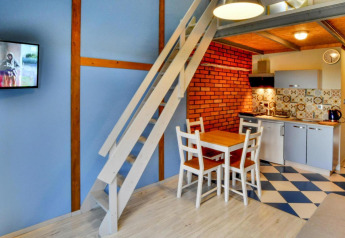 Moderne indretning i en lodge med hems, spiseområde, tekøkken og farverige vægge i Jezierzany, Danmark.