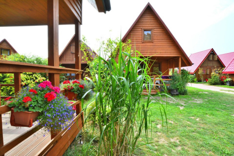 Accoglienti casette di legno con fiori e verde al lodge Domek 5-osobowy Jarosławiec in Danimarca.