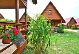 Houten huisjes met bloemenbakken en grasvelden bij Domek 5-osobowy Jarosławiec lodge in Denemarken.