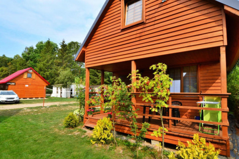 Houten lodge Domek 5-osobowy Jarosławiec met veranda, tuinplanten en auto in Denemarken.