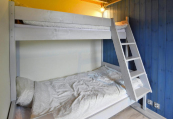 Room with a bunk bed and blue wood-paneled wall at Domki wakacyjne Jezierzany lodge in Denmark, cozy interior.