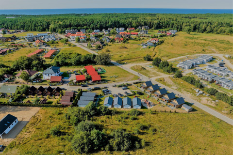 Luchtzicht op het Ustecka Osada 45m2 lodge omgeven door huisjes en natuur, vlak bij zee in Denemarken.
