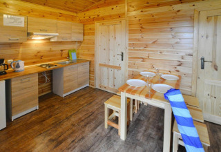 Gezellige houten keuken en eetruimte met gedekte tafel in Domki wakacyjne Przewłoka in Denemarken.