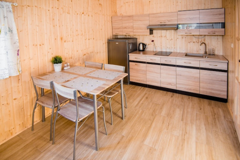 Moderne keuken en eettafel in Ustecka Osada 45m2 lodge, Denemarken, met licht houten interieur.