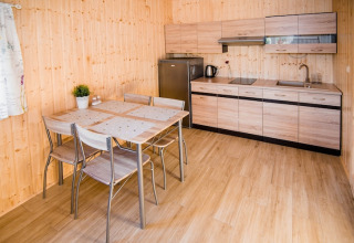 Moderne keuken en eettafel in Ustecka Osada 45m2 lodge, Denemarken, met licht houten interieur.