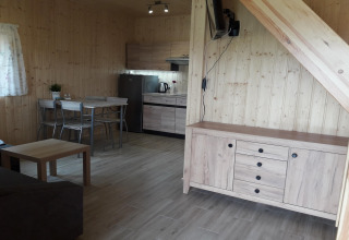 Woonkamer en keuken in de Ustecka Osada 45m2 lodge, houten interieur met moderne meubels in Denemarken.