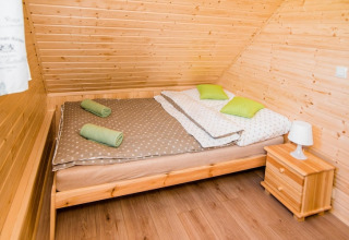 Knusse slaapkamer in lodge Ustecka Osada 45m2 in Denemarken met houtinrichting en tweepersoonsbed.