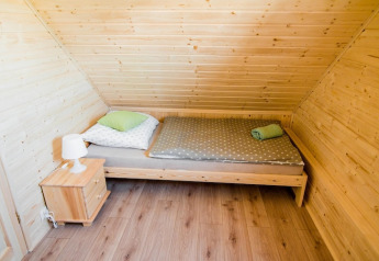 Gemütliches Schlafzimmer in Ustecka Osada 45m2 in Dänemark mit Dachschräge, Holzwänden und Einzelbett.