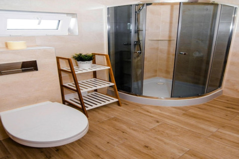 Moderne badkamer in Ustecka Osada 45m2, Denemarken, met douche, houten vloer, toilet en rek.