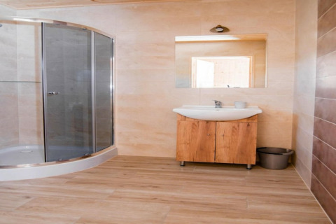 Moderne badkamer in Ustecka Osada 45m2 lodge in Denemarken met glazen douche en houten wasmeubel.