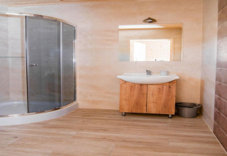 Moderne badkamer in Ustecka Osada 45m2 lodge in Denemarken met glazen douche en houten wasmeubel.