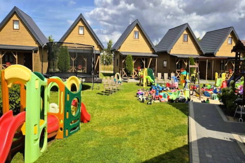 Speelplein met kleurrijk speelgoed en houten huisjes bij Ustecka Osada 45m2 lodge in Denemarken.