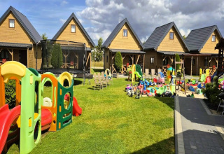 Speelplein met kleurrijk speelgoed en houten huisjes bij Ustecka Osada 45m2 lodge in Denemarken.