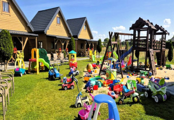 Spielplatz mit vielen Spielzeugautos, Rutschen und Holzhäusern bei Ustecka Osada 45m2 auf grünem Rasen.