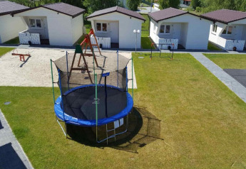 Feriehytter med legeplads, gynge, trampolin og sandkasse i grønt område ved Domki wakacyjne Przewłoka.