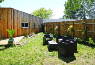 Area esterna con sedute al Holiday home «Le Porge» in Francia con lodge in legno, giardino e sedie