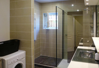 Baño moderno en Holiday home «Le Porge», Francia, con ducha, ventana y lavadora visibles en la imagen.