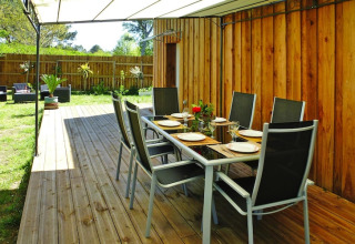 Area pranzo all'aperto con tavolo e sedie su terrazza in legno presso Holiday home «Le Porge» in Francia.
