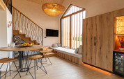 Interior de lodge moderno en Eslovenia con detalles de madera cálida, ventanales y zona de estar acogedora.