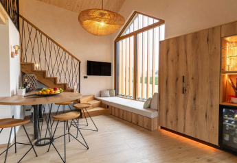 Modern vakantiehuis in Slovenië met warme houten elementen, grote ramen en sfeervolle zit- en eethoek.