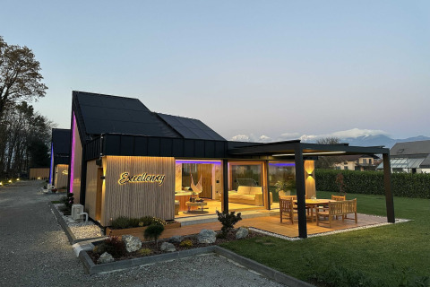 Evening view of Elegant Warm Bliss Hideaway Escape Lodge in Slovenia with cozy terrace and garden.