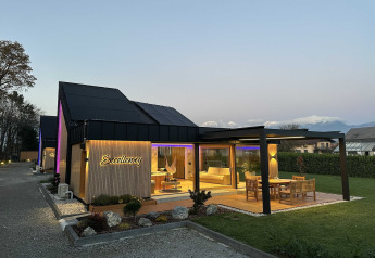 Vue au crépuscule de l’Elegant Warm Bliss Hideaway Escape Lodge en Slovénie, terrasse et jardin inclus.